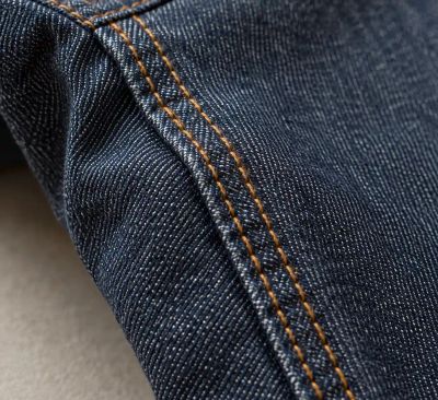A close-up of a flat-felled seam's two parallel rows of topstitching on denim.