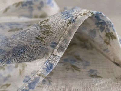 A finished French seam on lavender fabric, turned partway inside out to show the enclosed raw edge nested inside the outer stitching.