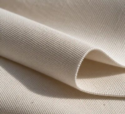 A close macro shot of cotton poplin's fine crosswise rib on a folded length of fabric.
