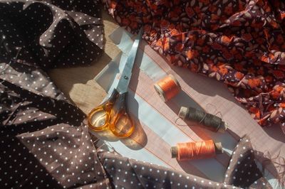 Scissors resting on pattern paper next to floral and polka-dot fabric.